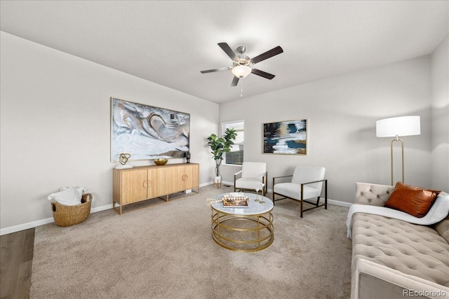 living area featuring carpet floors, ceiling fan, and baseboards