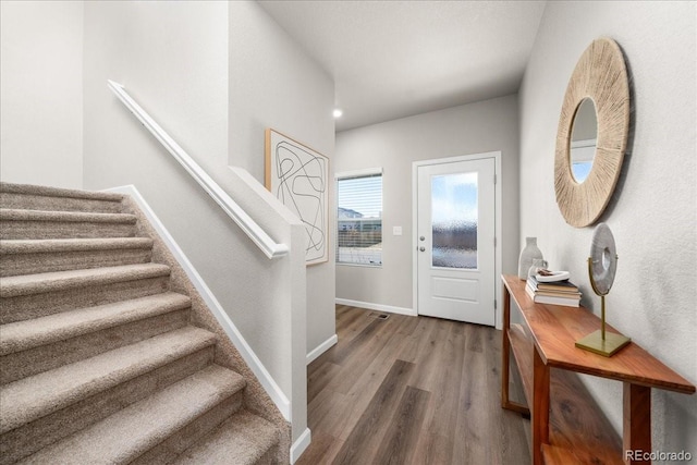 foyer entrance featuring stairway, baseboards, and wood finished floors