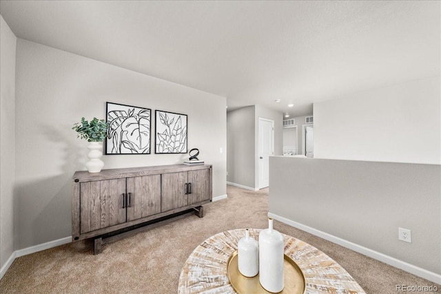 sitting room featuring visible vents, baseboards, and light colored carpet