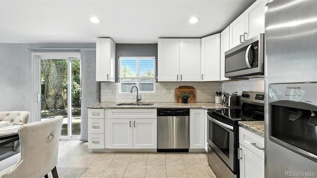 2829 Illinois Ave, Colorado Springs, CO 80907 - kitchen featuring stainless steel appliances, backsplash, light tile patterned floors, white cabinetry, and recessed lighting