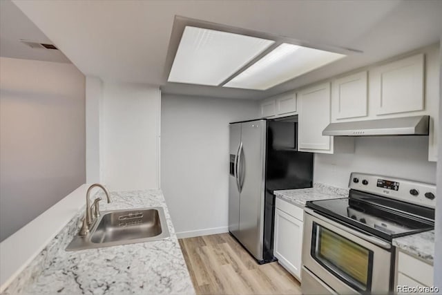 kitchen with light wood-type flooring, sink, light stone countertops, white cabinets, and appliances with stainless steel finishes