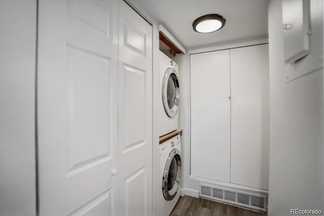 7870 W 87th Dr Unit J, Arvada, CO 80005 - washroom featuring laundry area, stacked washing maching and dryer, visible vents, and dark wood-type flooring