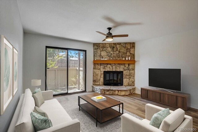 7870 W 87th Dr Unit J, Arvada, CO 80005 - living room with ceiling fan, a stone fireplace, and wood finished floors