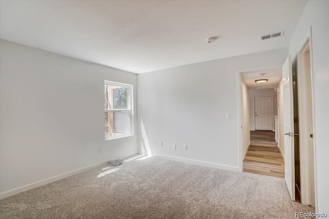 7870 W 87th Dr Unit J, Arvada, CO 80005 - unfurnished room with baseboards, visible vents, and light colored carpet