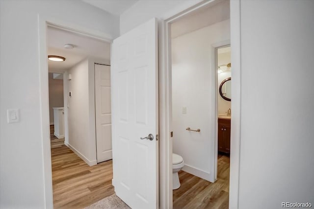 7870 W 87th Dr Unit J, Arvada, CO 80005 - hall featuring light wood-style flooring, baseboards, and a sink
