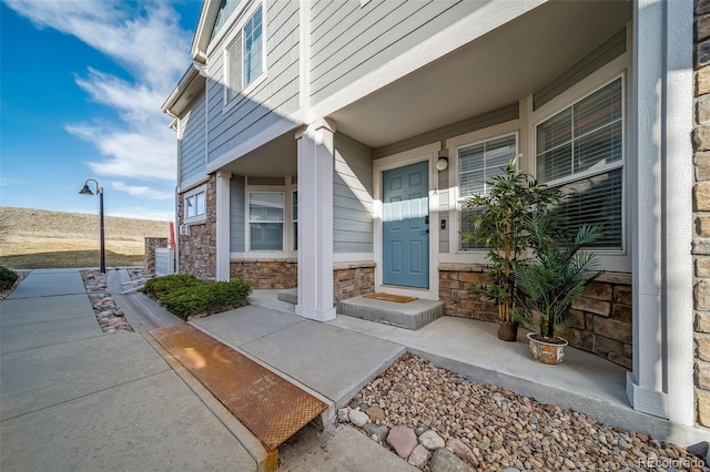 entrance to property with stone siding and covered porch