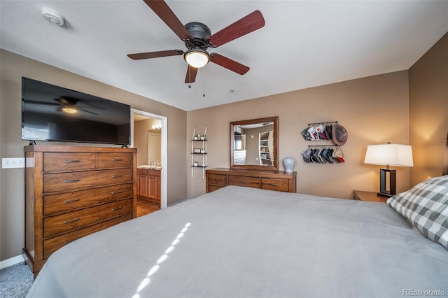 bedroom featuring ceiling fan, baseboards, ensuite bath, and carpet flooring