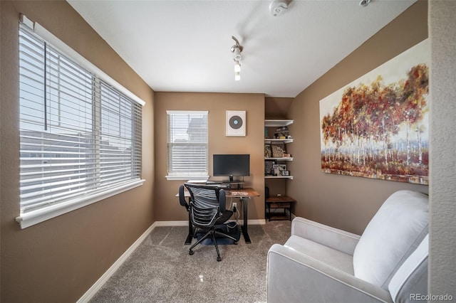 carpeted home office featuring track lighting and baseboards