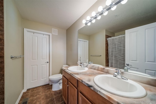 bathroom featuring a shower with shower curtain, toilet, visible vents, and a sink