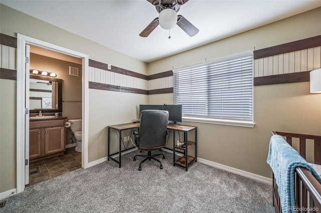 carpeted home office featuring visible vents, baseboards, and ceiling fan