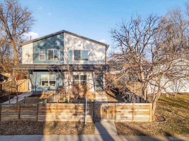 contemporary home featuring a fenced front yard and a gate