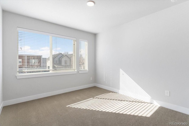 empty room with baseboards and carpet