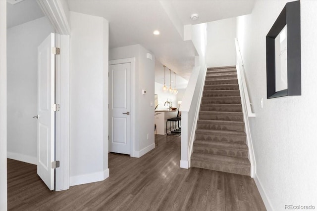 stairs with recessed lighting, wood finished floors, and baseboards