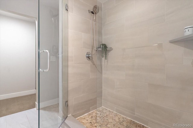 bathroom with a shower stall and baseboards