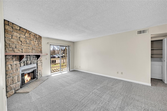 unfurnished living room with visible vents, carpet floors, a stone fireplace, heating unit, and washer / clothes dryer