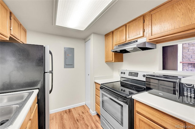 kitchen featuring under cabinet range hood, electric panel, a sink, stainless steel appliances, and light wood-style floors