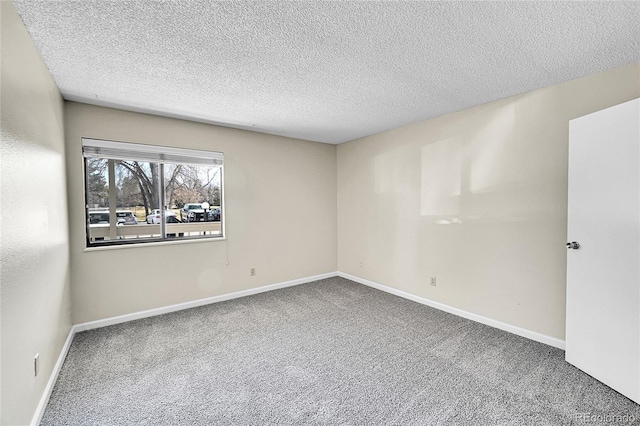 unfurnished room featuring baseboards, carpet floors, and a textured ceiling