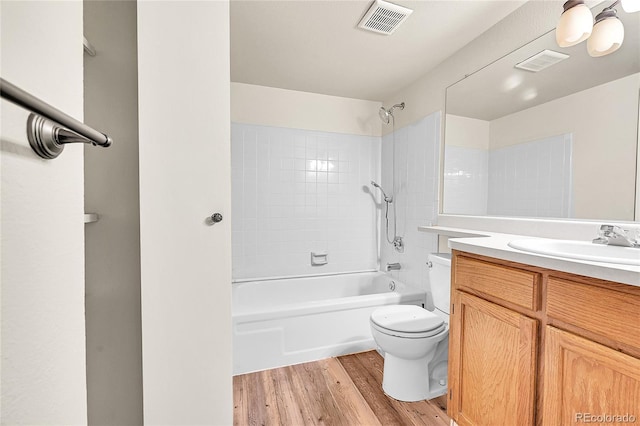 bathroom with visible vents, toilet, vanity, and wood finished floors