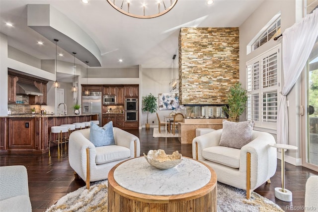 living room with dark hardwood / wood-style floors, a notable chandelier, and sink