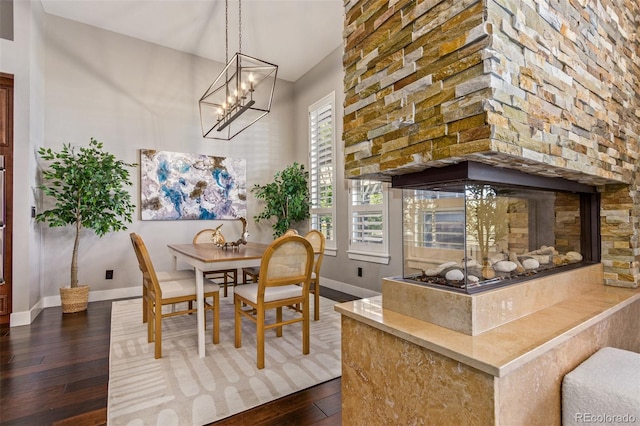 dining space with hardwood / wood-style flooring, a healthy amount of sunlight, and a fireplace