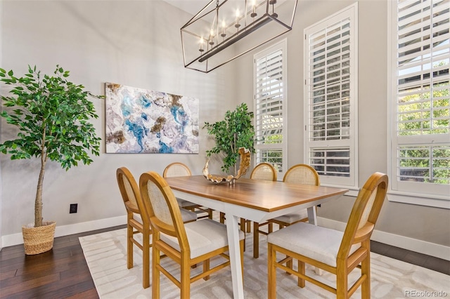 dining space featuring hardwood / wood-style flooring and an inviting chandelier