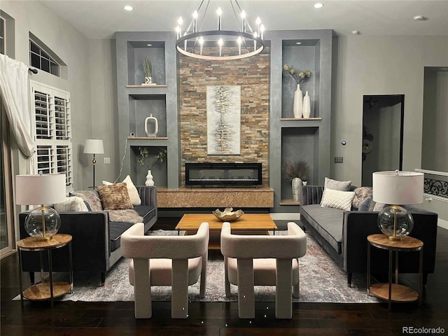 living room with dark hardwood / wood-style flooring, built in features, and a notable chandelier