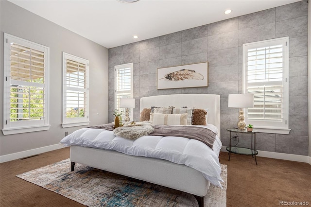 bedroom with carpet, tile walls, and multiple windows