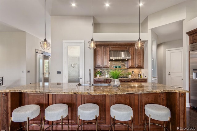 kitchen featuring hanging light fixtures, a barn door, and range hood