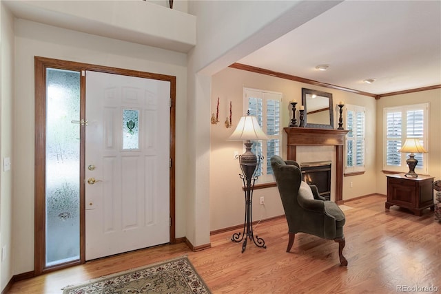 10032 Astoria Ct, Lone Tree, CO 80124 - entrance foyer featuring light wood finished floors, ornamental molding, and a glass covered fireplace
