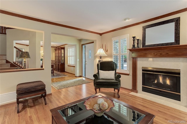 10032 Astoria Ct, Lone Tree, CO 80124 - living room featuring stairs, light wood-type flooring, ornamental molding, and a tile fireplace