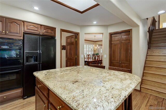 10032 Astoria Ct, Lone Tree, CO 80124 - kitchen with black appliances, light stone counters, light wood-type flooring, a center island, and recessed lighting