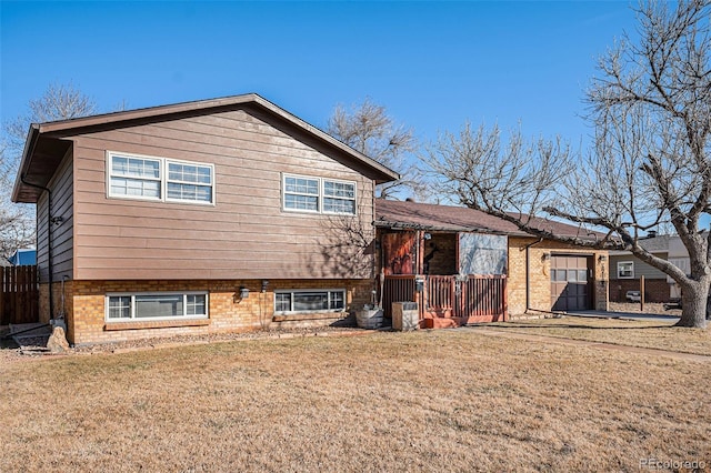 rear view of house with fence, a lawn, and brick siding