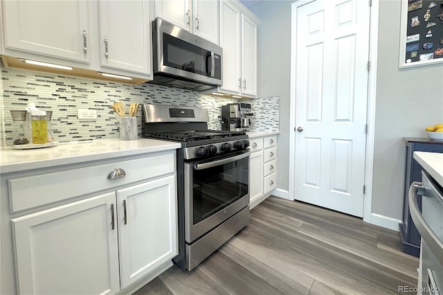 kitchen with tasteful backsplash, appliances with stainless steel finishes, dark hardwood / wood-style floors, and white cabinets