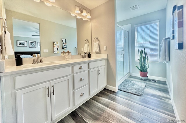 bathroom featuring vanity, wood-type flooring, and a shower with shower door