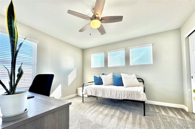 bedroom featuring ceiling fan, light colored carpet, and a textured ceiling