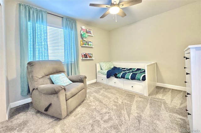 living area with ceiling fan and carpet