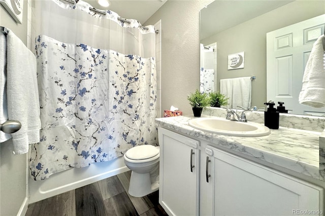 full bathroom with vanity, hardwood / wood-style flooring, toilet, and shower / bath combo with shower curtain