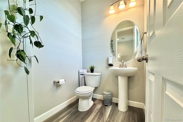 bathroom with sink, hardwood / wood-style floors, and toilet