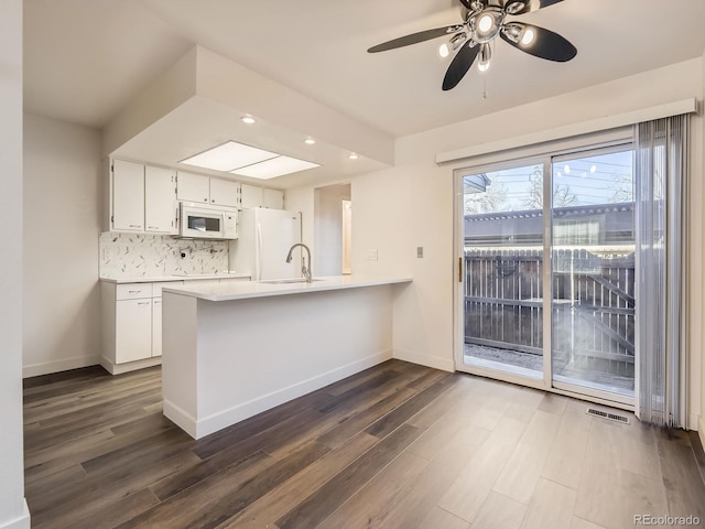 kitchen with light countertops, visible vents, decorative backsplash, white cabinetry, and white appliances