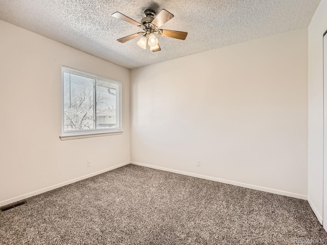 spare room featuring carpet floors, baseboards, a ceiling fan, and a textured ceiling