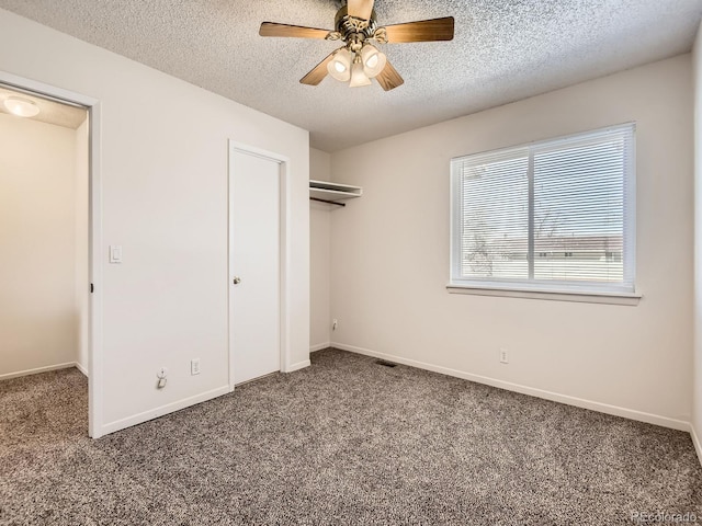 unfurnished bedroom featuring a closet, carpet flooring, a textured ceiling, and baseboards