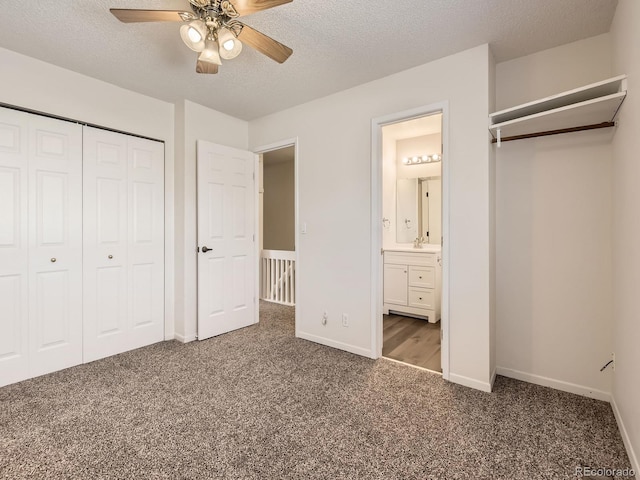 unfurnished bedroom featuring a textured ceiling, a closet, baseboards, and carpet flooring