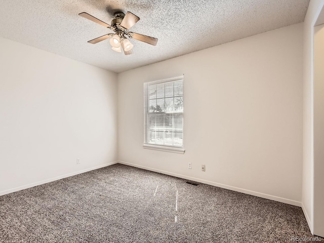 spare room with baseboards, carpet floors, visible vents, and a ceiling fan