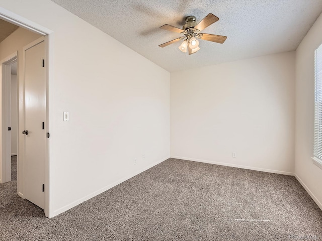 carpeted empty room featuring baseboards, a ceiling fan, and a textured ceiling