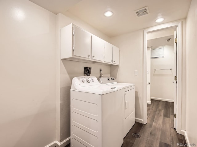 clothes washing area with cabinet space, baseboards, visible vents, washer and clothes dryer, and dark wood-type flooring