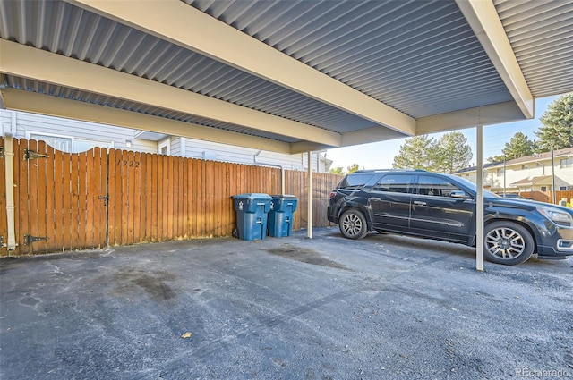 covered parking lot featuring fence