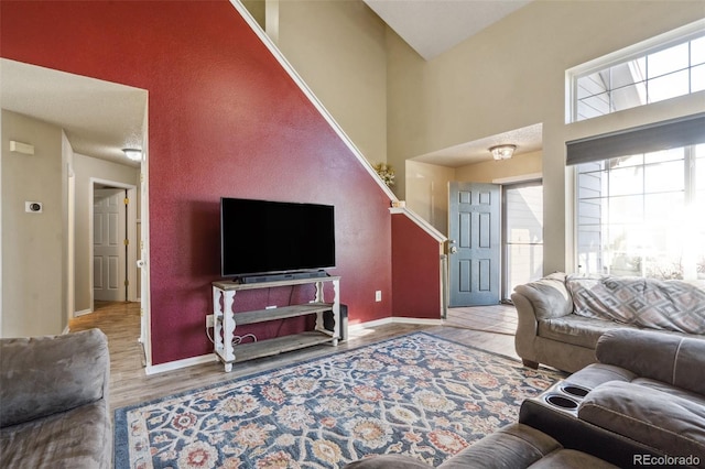 living room with light hardwood / wood-style flooring and high vaulted ceiling