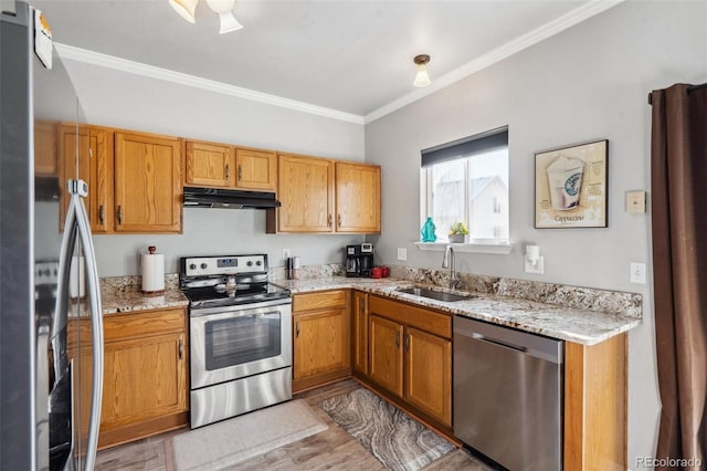 kitchen with stainless steel appliances, crown molding, light stone counters, sink, and light hardwood / wood-style flooring