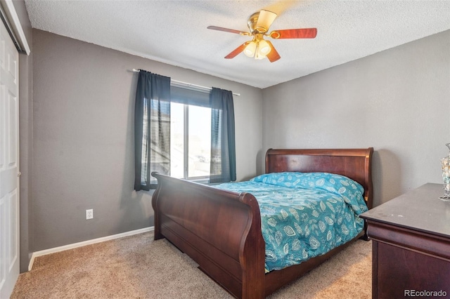 carpeted bedroom with a closet, ceiling fan, and a textured ceiling