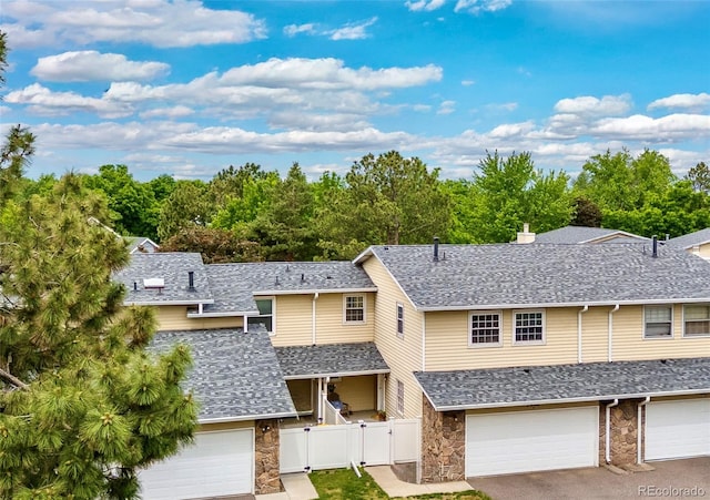 2650 S Vaughn Way Unit B, Aurora, CO 80014 - view of front facade with a garage, roof with shingles, and stone siding